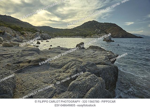 Beautiful Mediterranean beach typical of the coast of southern Sardinia taken over in summer. The beach, the rocks and the mountains behind blend in a wonderful...