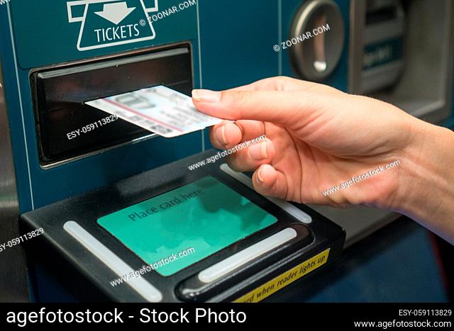 Closeup of woman's hand receiving ticket from self service machine