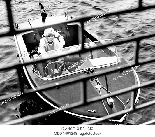 Portrait of Gisella Pagano driving a motorboat. Portrait of Italian painter, director and showgirl Gisella Pagano driving a motorboat. Lierna, 1970s