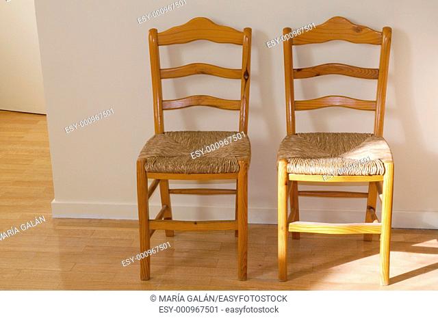 Two wooden chairs, with wickerwork seats