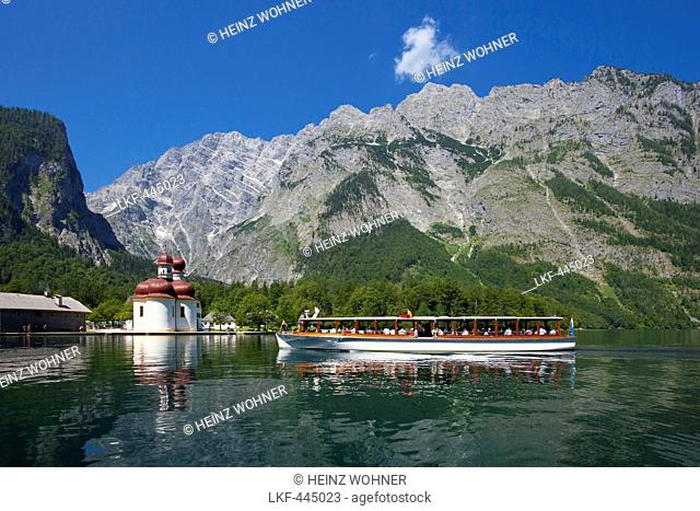 Excursion boat in front of baroque style pilgrimage church St Bartholomae, Watzmann east wall in the background, Koenigssee, Berchtesgaden region