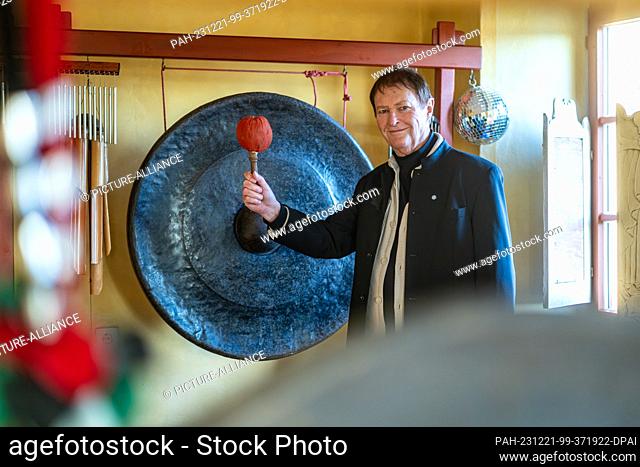 19 December 2023, Bavaria, Geiselhöring: Hans-Jürgen Buchner from the music group Haindling stands next to a large gong in his house in Haindling