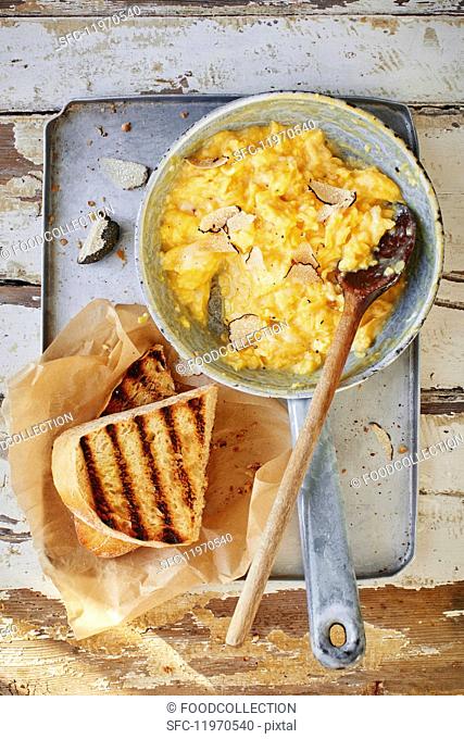 Scrambled egg with truffles in a pan with toast