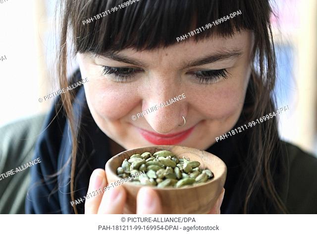 06 December 2018, Bremen, Bremerhaven: Laura Brandt, founder of the online spice trade ""yummy organics"", smells of a bowl with cardamom
