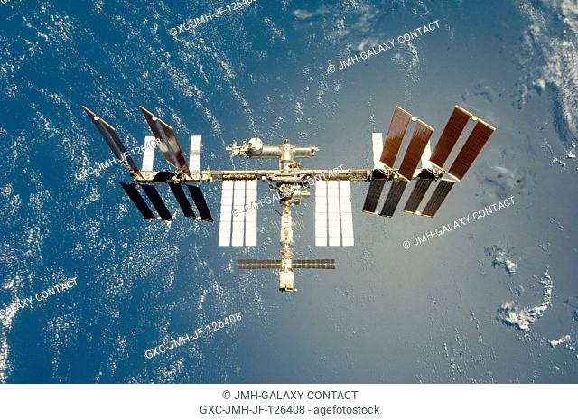 Backdropped by a blue and white Earth, the International Space Station is seen from Space Shuttle Endeavour as the two spacecraft begin their relative...