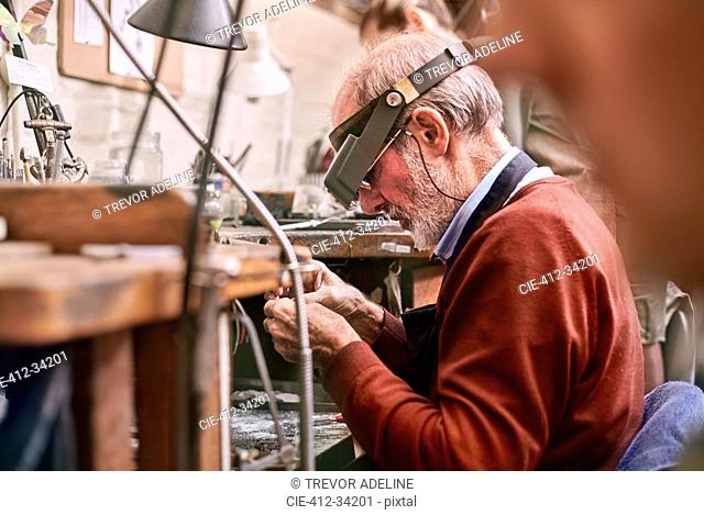Jeweler wearing headband magnifier working in workshop