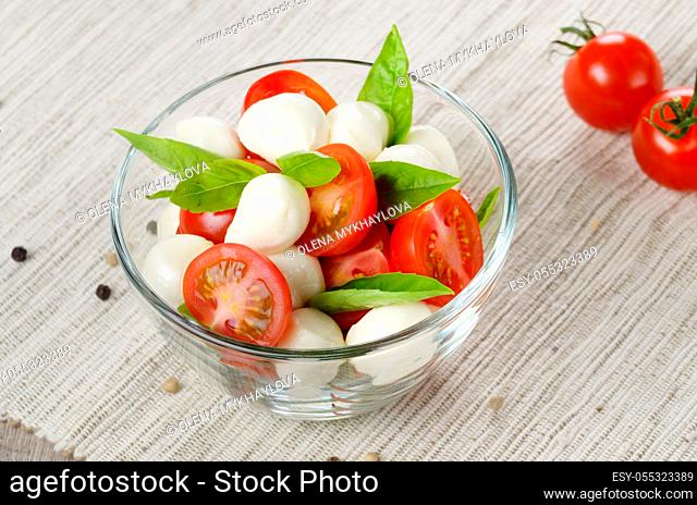 Homemade Caprese salad in glass bowl with italian bread