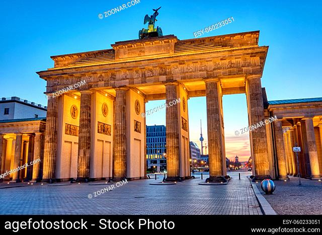 Das Brandenburger Tor mit dem Fernsehturm im Hintergrund vor Sonnenaufgang, gesehen in Berlin, Deutschland