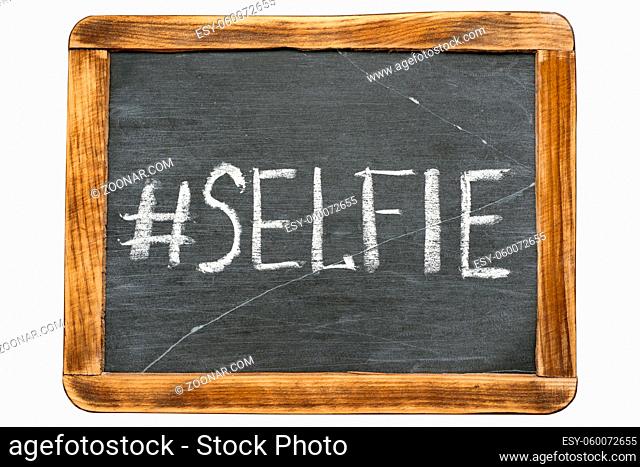 selfie hashtag handwritten on vintage school slate board isolated on white