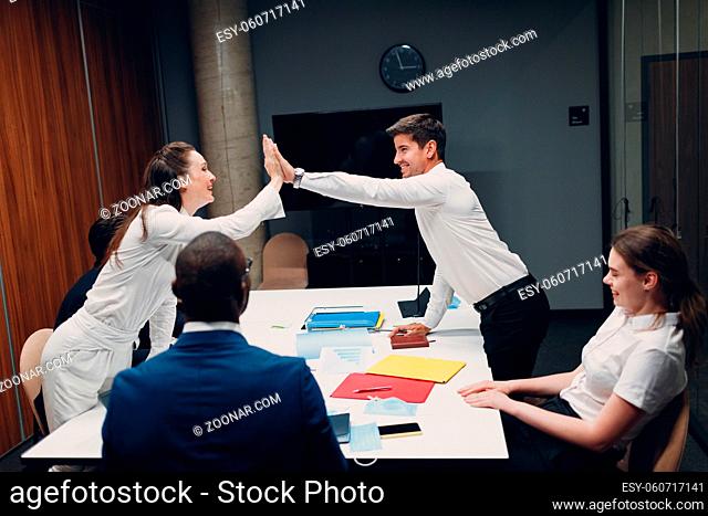 Businessman and businesswoman team at office meeting. Business people group conference discussion give high five deal and success