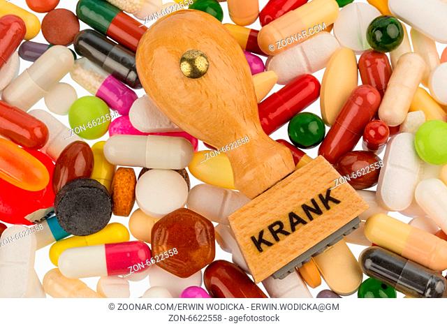 Stempel auf bunten Tabletten, Symbolfoto für Krankheit, Krankschreibung und Medikamente