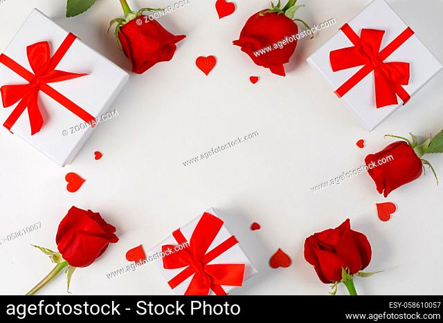 Red rose flowers hearts and gifts composition on white background top view with copy space. Valentine's day, birthday, wedding, Mother's day concept
