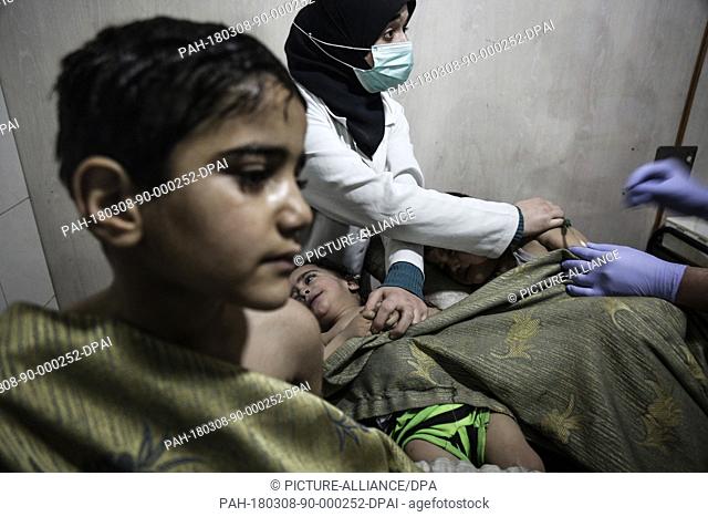 dpatop - Syrian children receive first aid after what local sources say was an attack by forces loyal to Syrian President Assad with chlorine gas on the town...