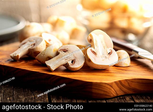 Fresh white champignon mushrooms on cutting board