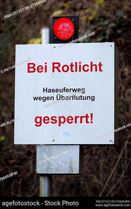 21 December 2023, Lower Saxony, Osnabrück: ""Closed at red light"" is written on a sign on the banks of the River Hase. The German Weather Service is expecting...