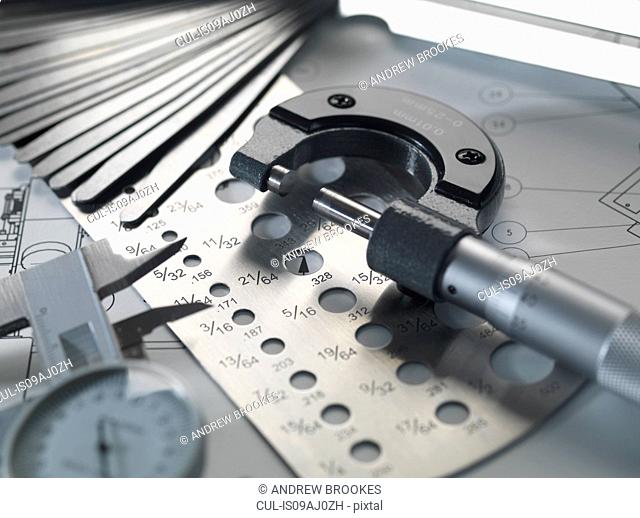 Engineering design - micrometer, feeler gauge and screw gauge on blueprint