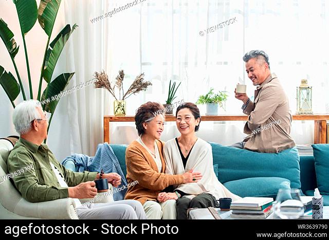 Happy old people sitting in the living room to chat over a cup of tea
