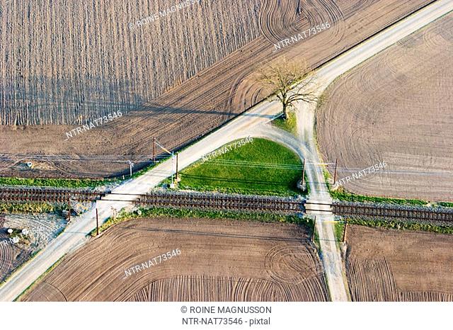 Gravelled roads in agricultural district and a railway, aerial view, Skane