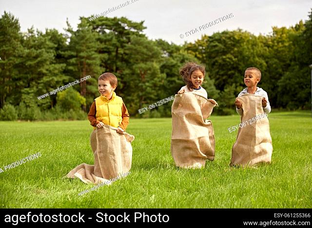 happy children playing bag jumping game at park