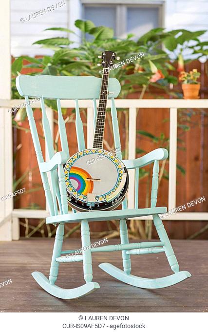 Banjo and rocking chair on outside porch