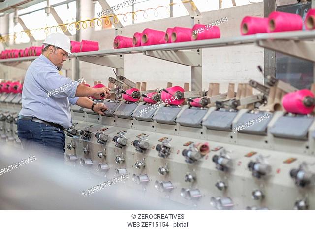 Man working with spools in factory