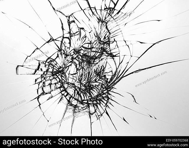 Cracks pattern on broken glass, abstraction of chips and lines from impact on glass