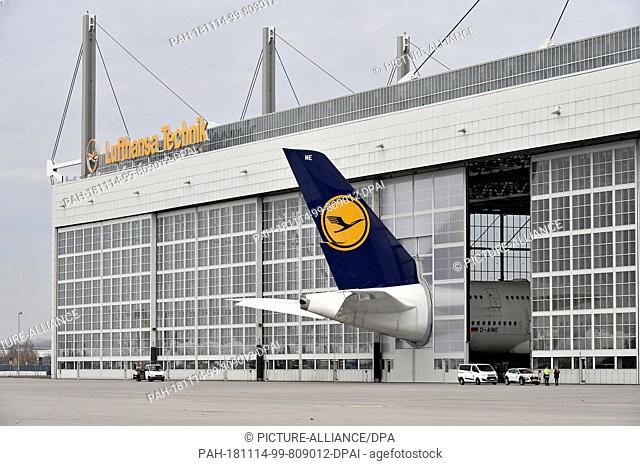 HANDOUT - 08 November 2018, Bavaria, München: The tail fin of a Lufthansa Airbus A380 protrudes from a hangar at Munich Airport