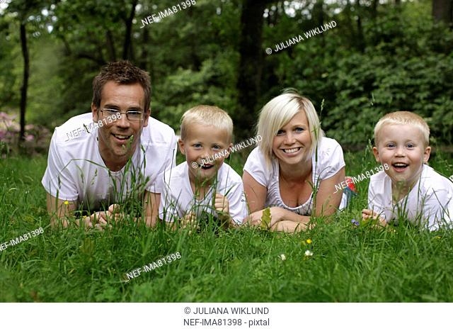 Family lying on grass, Sweden