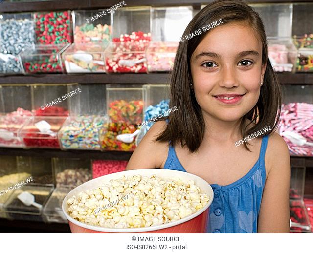 Girl holding a tub of popcorn