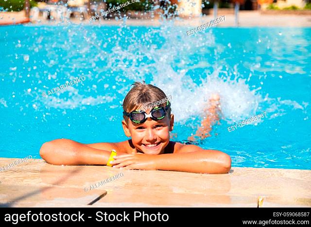 Active lifestyle of Happy boy with goggles in the swimming pool Summer vacation concept