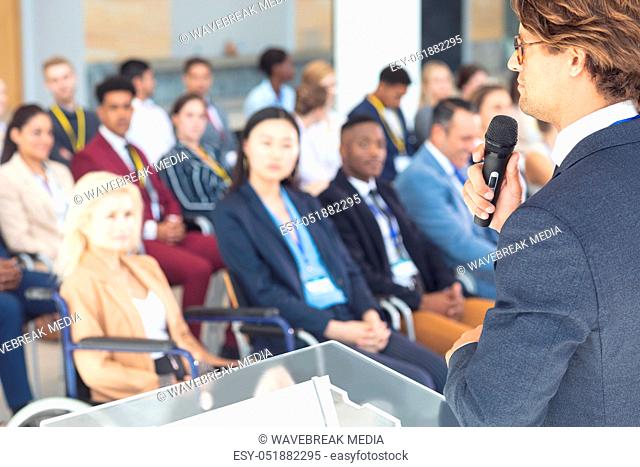 Caucasian businessman doing speech in conference room