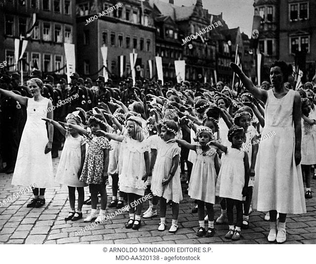 Military parade of Nazi Assault Teams. A female student body making the Nazi salute during a military parade of the SA (Assault Squad) of the Nazi Party