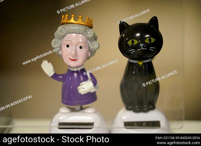 06 November 2023, Hamburg: Wobbly figures in the shape of a cat and Queen Elizabeth II stand on the reception counter in the vaccination center at the Institute...