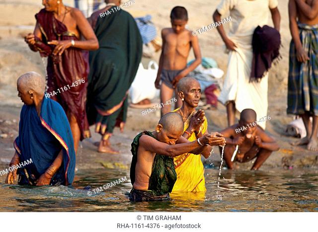 Indian Hindu pilgrims bathing in The Ganges River at Dashashwamedh Ghat in Holy City of Varanasi, Benares, India