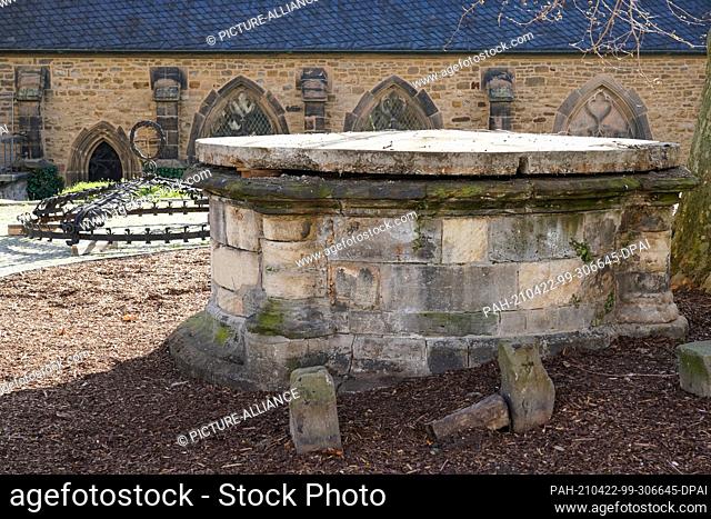 22 April 2021, Saxony-Anhalt, Merseburg: Behind the still covered Merseburg Cathedral fountain lies the bow crown of the fountain on the cathedral square at...