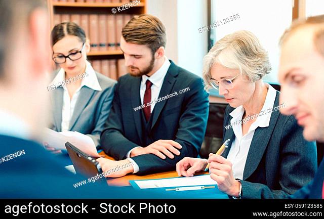Team of partners in a law firm working in their office diligently on a case