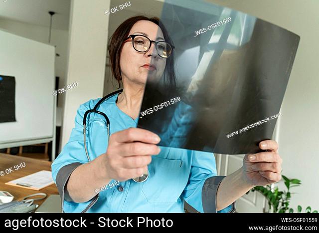 Concentrated doctor examining X-ray at medical practice