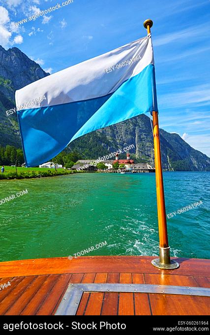 Bootsfahrt auf dem Königssee mit Blick auf die berühmte Wallfahrtskirche St. Bartholomä und der bayerischen Fahne. In Deutschland, Bayern