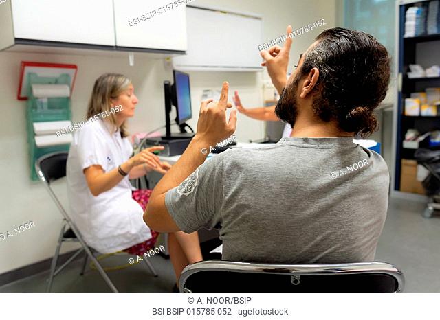 Care for deaf patients in sign language, Nice Hospital, France. Consultation with a patient who is under 40 and deaf, suffering from Usher syndrome