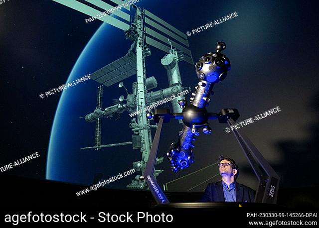 PRODUCTION - 27 March 2023, Saxony-Anhalt, Halle (Saale): Dirk Schlesier, director of the planetarium, stands in front of a projection of the ISS space station...