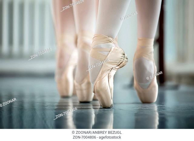 Legs dancers on white pointe, near the choreographic training ma