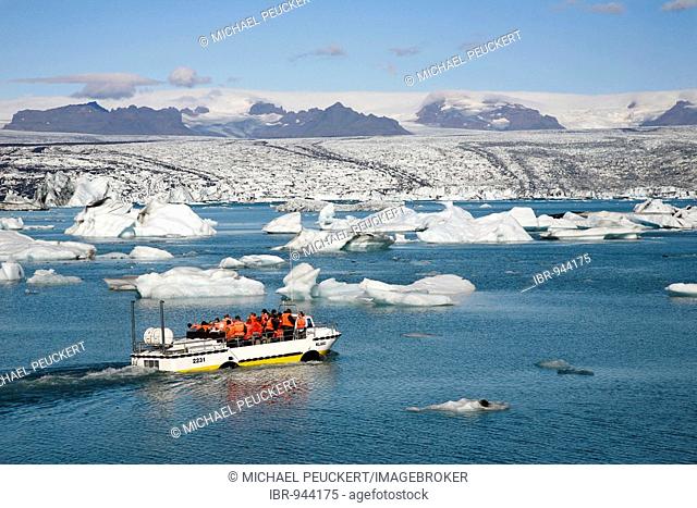 In the Joekulsarlon glacier lagoon of the Vatnajoekull Glacier, people travelling in an boat between the floating icebergs