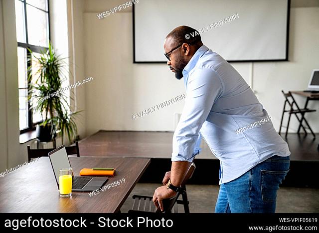Businessman looking at laptop screen in conference room