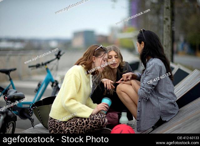 Young women friends talking in city