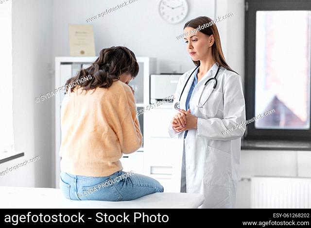 female doctor talking to sad woman at hospital