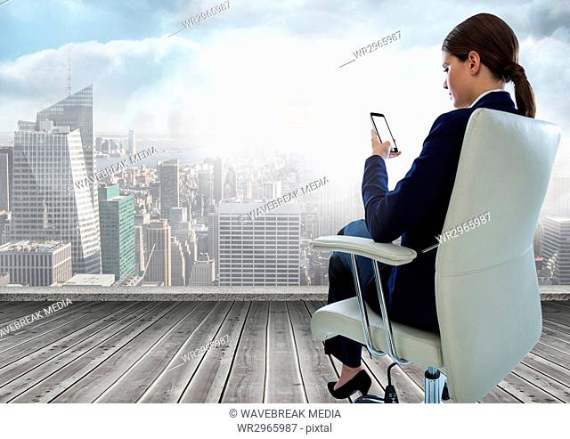 Businesswoman Back Sitting in Chair with mobile phone over city