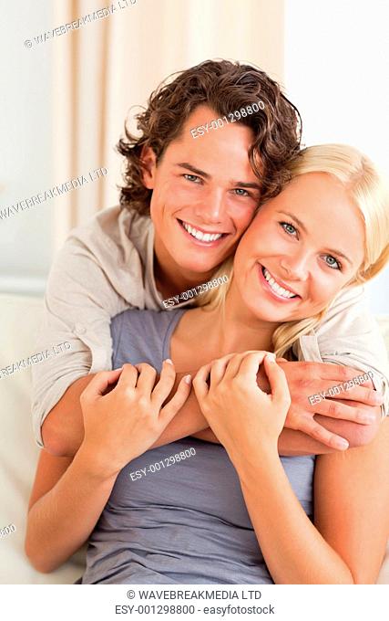 Portrait of a young couple embracing each other while looking at the camera