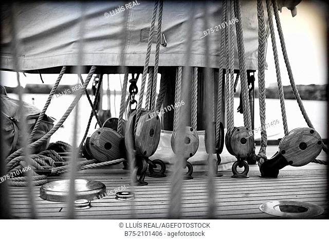 Closeup of a classic sailboat deck with pulleys, ropes, and sails at the Port Mahon, Menorca, Balearic Islands, Spain