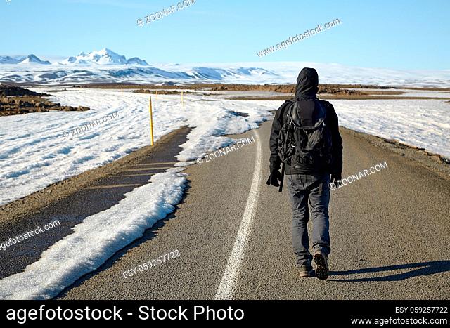 Man standing on the road heading toward the unknow snowy parts