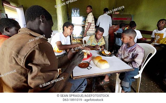 Ethiopia. The 'Salam Café' in Chagni, Beni Shangul Gumuz region.  Boys having breakfast of beans
